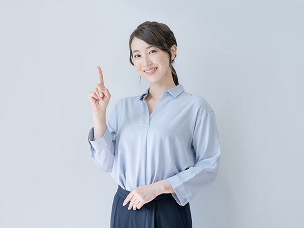 人差し指を立てて微笑む女性