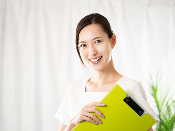 カルテを持って微笑む女性
