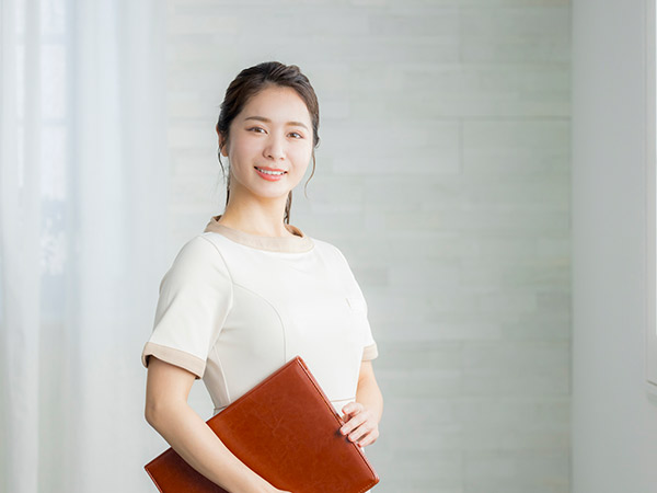 カルテをもって微笑む女性