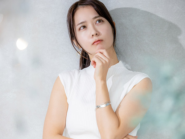 顎に手をあて悩む女性